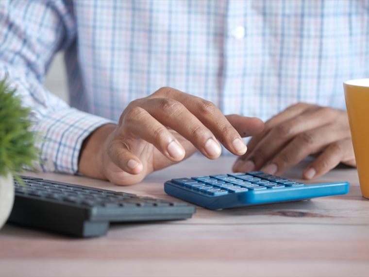 Working through figures on a desktop calculator at a tidy office desk