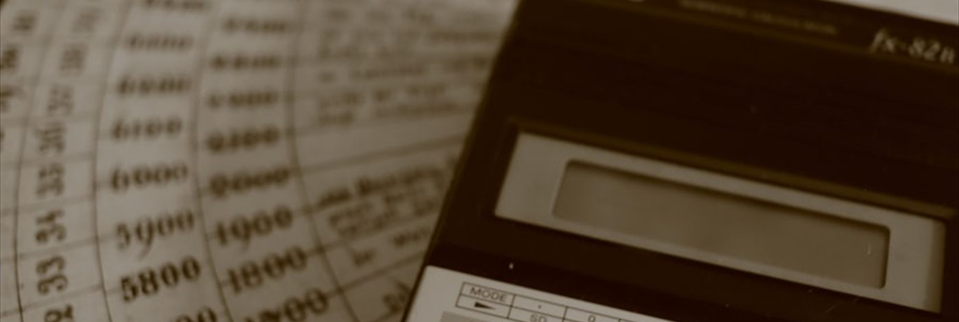 A calculator resting on columns of figures in an accounting ledger